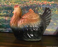 Full side view of glazed ceramic hen dish with lid