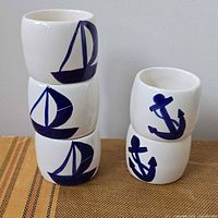Five ceramic napkin rings showing sailboat and anchor artwork