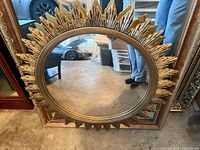 Front view of gold gilt sunburst wall mirror showing overall design and mirror surface