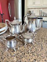 Group shot of all four silver-plated pieces on countertop