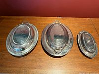 Three silver-plated covered dishes with lids in place