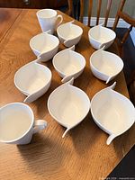 Group shot of all eight bowls and two mugs on table