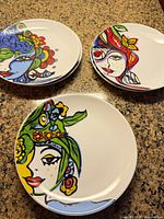 Top view showing three stacks of two plates with colorful female face motifs