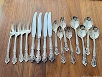 All 16 flatware pieces laid out: 4 forks, 4 knives, 4 teaspoons, 4 soup spoons