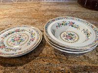 Stacks of dessert plates and shallow bowls on countertop