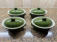 Four green Hall covered oval casseroles with lids displayed
