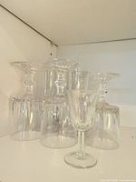 Eight pressed glass stemmed pieces inverted to show stems and rims