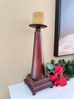 Wood veneer candle holder on base with yellow candle