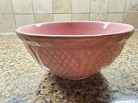 side view of pink ceramic bowl showing exterior texture and shape