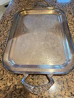 Top view of silver-plated rectangular tray showing engraved pattern, raised rim and both ornate handles