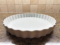 Side profile showing fluted edge and white glaze of dish