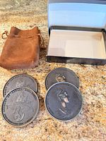 overview of four medallions, suede pouch, empty box