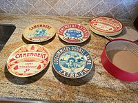 All four decorative Camembert plates plus packing lid shown for scale and design overview