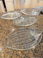 All four leaf-shaped plates with cups displayed on countertop