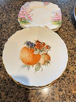 Stack of Bavarian fruit pattern plates foreground, Royal Albert blossom plates behind
