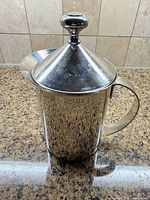 Full view of stainless steel French press with lid on