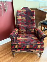 Front view of armchair showing upholstery, tufted back, rolled arms, seat cushion and pillow