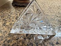 Front view of triangular cut glass napkin holder showing starburst pattern