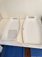 Both white ceramic platters side by side showing sizes and handle cutouts