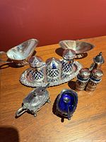 Group shot showing all silver-plated pieces including gravy boats, oval tray with lattice set, pair of shakers, salt cellars with spoons