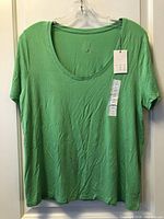 Front view of lime green top showing scoop neck, short sleeves, new tags attached