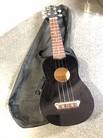 Full ukulele front view on top of soft gig bag
