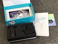 Box opened showing wiring harness, sensor probe, mounting bracket, and manual