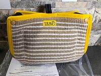 Front view of striped jute bite wedge with Yes4Quality label, yellow trim, black handle, instruction sheet visible