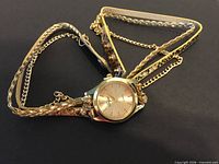 Watch laid out showing multi-strand wrap strap and dial