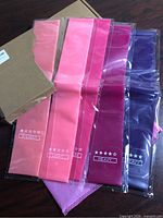 Five colour-coded resistance bands in packaging beside box