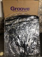 Box marked Groove rain cover with sealed plastic-wrapped cover visible