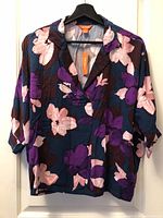 Front view of Joe Fresh floral blouse showing pattern, collar, sleeves and hang tag