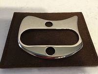 Front view of stainless steel gua sha tool on brown pouch