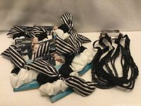 Group shot of eight packages of Goody Gentle Scrunchies and three black headbands