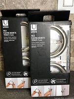 Front view of two sealed Umbra Halo tieback boxes