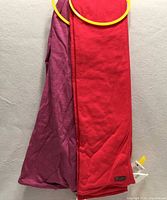 Red and purple Lole scarves with tags on yellow hanger rings