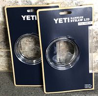 Front view of both sealed Yeti Rambler 20 oz straw lids in retail packaging