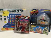 All three sealed toys: Connect Four game box, red voice changer, Battle Ballz pack