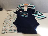 Three bodysuits laid out showing colours and prints