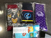 Four sealed pairs of novelty dress socks
