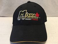 Front view of one cap showing Miska Trailer Factory logo