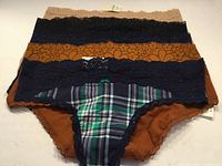 Five pairs of underwear stacked showing colors and lace waistband