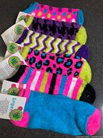 Six pairs assorted Gripeeze fuzzy socks with tags attached