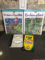 Group shot: two Creative Haven coloring books, Secret Garden postcard book, Crayola 24 colored pencils