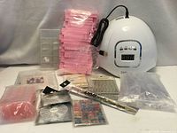 Overall lot with SUN X5 lamp, buffers, nail tips, rhinestone wheels, tools and stickers