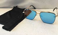 Front view showing blue mirrored lenses, frame and pouch with cloth