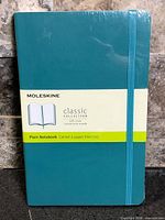 Front view of sealed Moleskine Classic Collection teal soft cover plain notebook