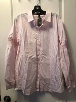 Front view of blouse on hanger showing collar, buttons, tags