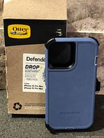 Front view of OtterBox Defender case and box showing model compatibility and color