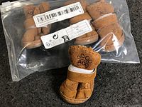 Sealed bag showing all four small tan pet booties
